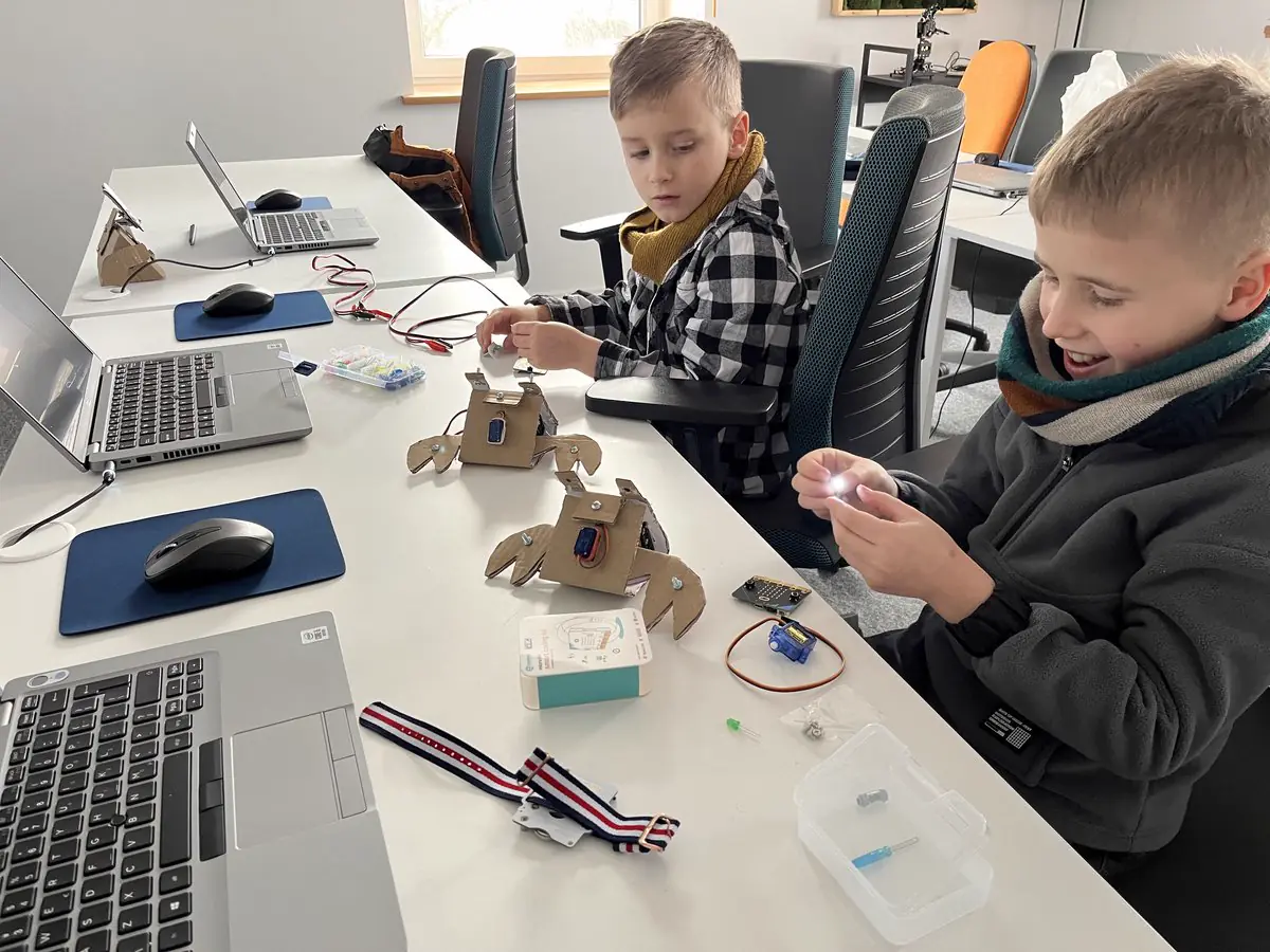 Dziecko z robotem na warsztatach JuniorAI